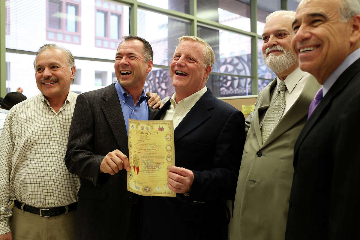Vic Holmes, center/left, and Mark Phariss hold their marriage license, issued moments earlier, as they celebrate with Frank Stenger-Castro, one of their attorneys and a friend, from left, Bexar County Clerk Gerry Rickhoff and former Congressman Charlie Gonzalez at the Bexar County Marriage License Office in the Paul Elizondo Tower in San Antonio on Friday, Sept. 25, 2015.