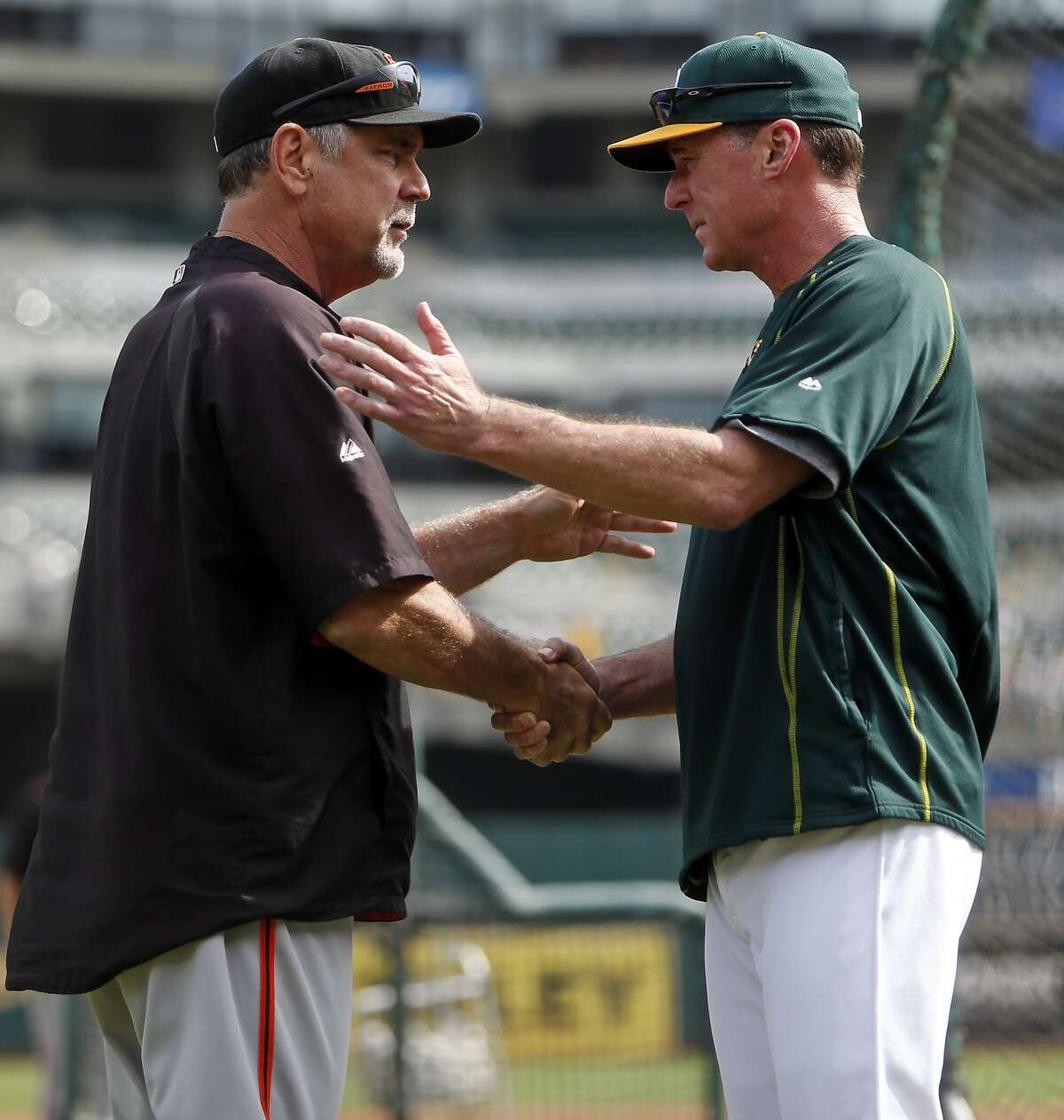 San Francisco Giants' manager Bruce Bochy greets Oakland A's manager Bob Melvin before MLB game at O.co Coliseum in Oakland, Calif., on Sunday, September 27, 2015.