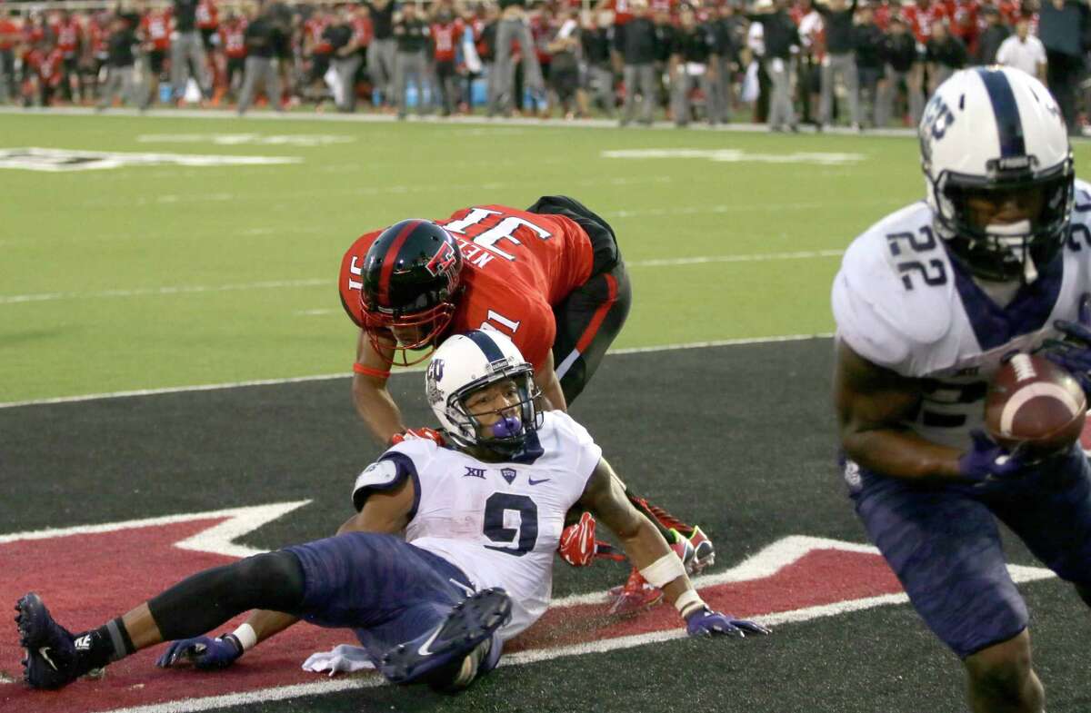 Texas Tech defensive back Justis Nelson (31) grabs TCU wide receiver Josh Doctson (9) after a pass was deflected to running back Aaron Green (22) for a touchdown during the fourth quarter on Sept. 26, 2015, in Lubbock, Texas.