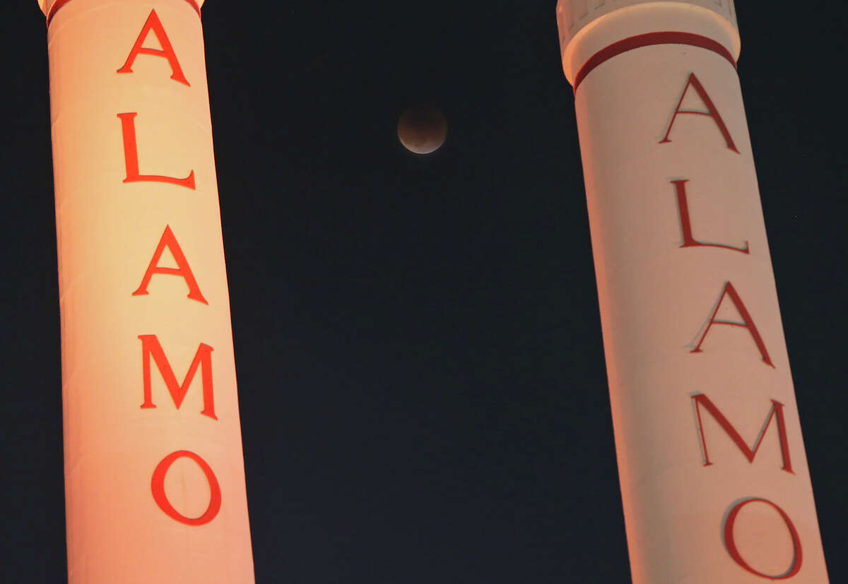 A view of the blood moon eclipse between the smokestacks at the Alamo Quarry Market Sunday Sept. 27, 2015.