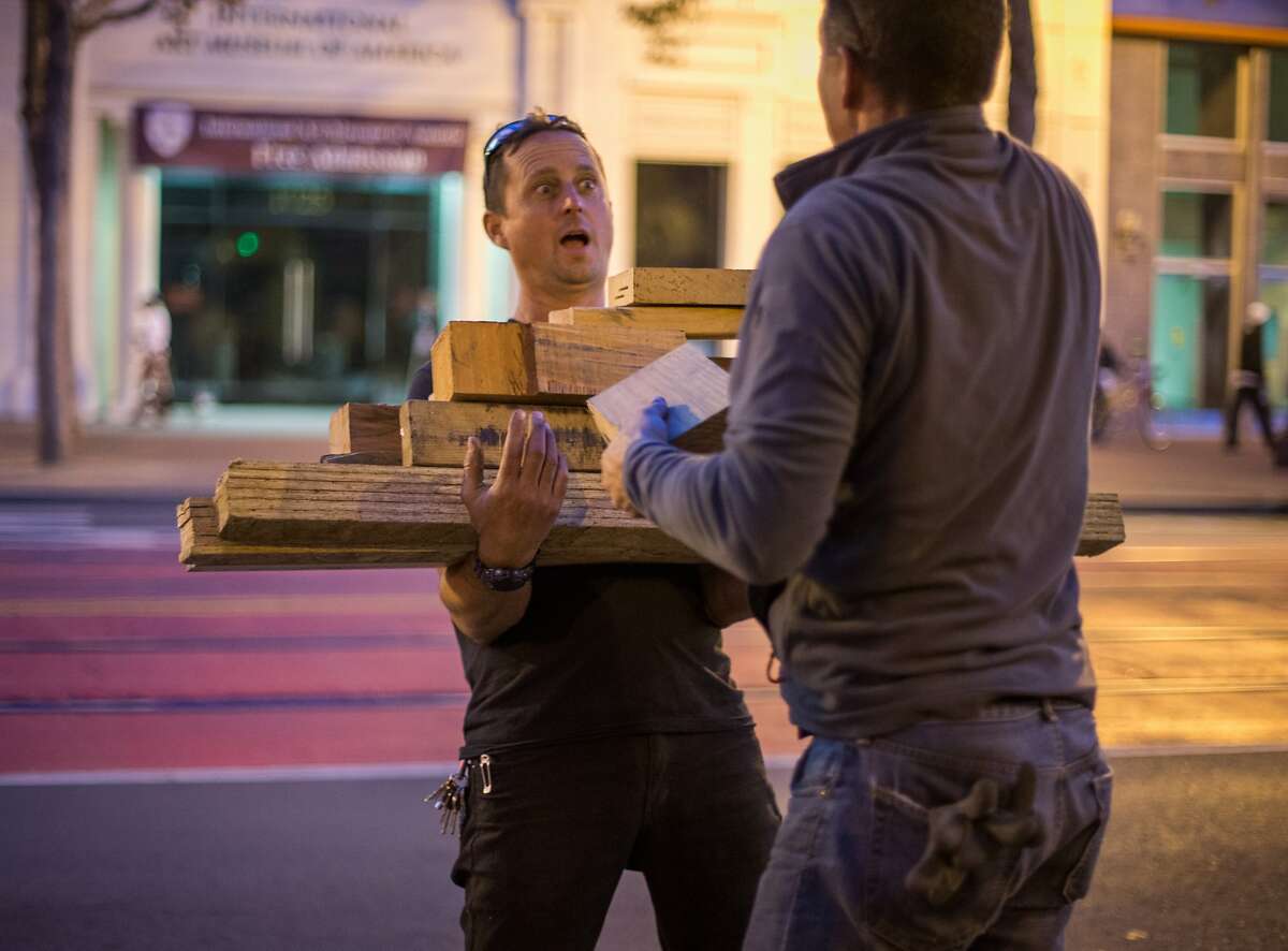 Paul Troutman carries unused wood scraps from the construction of San Francisco's newest Living Innovation Zone designed by artist Marisha Farnsworth and funded by the Kenneth Rainin Foundation, on Market Street between 6th and 7th streets on Sunday, Sept. 27, 2015 in San Francisco, Calif. The installation will open with a ceremony on Wednesday Sept. 30, 2015.