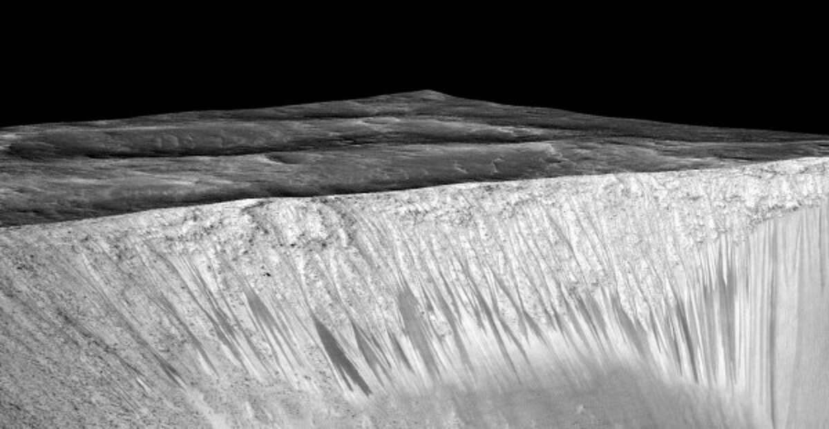 Dark narrow streaks called recurring slope lineae emanating out of the walls of Garni crater on Mars. The dark streaks here are up to few hundred meters in length. They are hypothesized to be formed by flow of briny liquid water on Mars.