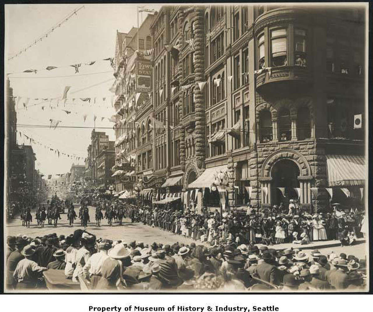 "Seattle’s first Golden Potlatch festival opened on July 17, 1911. The city-wide summer celebration was conceived by civic groups to celebrate the Klondike gold rush and capitalize on the success of the Alaska-Yukon-Pacific Exposition of 1909. The week-long festival included concerts, parades, aircraft and boat demonstrations. Seattle’s annual Seafair celebrations each July continue the Potlatch tradition. In this photograph, a formation of horses heads south on First Avenue toward James Street, approaching a turn in front of the Pioneer building. Streamers of flags decorate the buildings along the parade route." -MOHAI