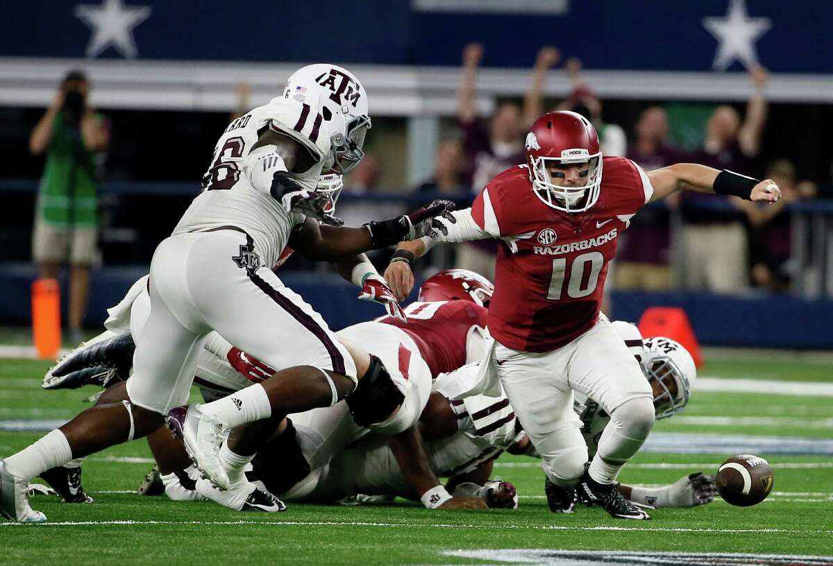 Texas A&M linebacker A.J. Hilliard (left) moves in to recover a ball fumbled by Arkansas quarterback Brandon Allen (10) during the second half on Sept. 26, 2015, in Arlington. A&M recovered on the way to a 28-21 overtime win.