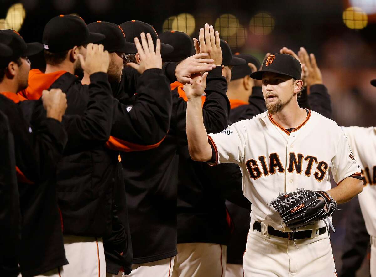 Mike Leake #13 of the San Francisco Giants is congratulated by teammates after they beat the Los Angeles Dodgers at AT&T Park on September 30, 2015 in San Francisco, California.