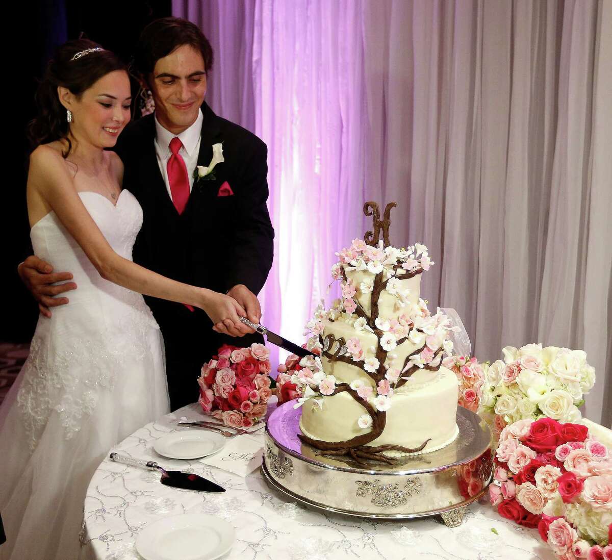 Catherine and Peter cut their cake during the reception for their "Wish Upon a Wedding" wedding at Hotel Derek on Tuesday, Sept. 8, 2015. Catherine and Peter are from McAllen. Catherine suffers from cystic fibrosis and is currently awaiting a double-lung transplant that could extend her life. Wish Upon a Wedding is a non-profit that utilizes high end wedding planners and photographers to give their talents to make dreams come true for couples facing life threatening ordeals to be able to find hope. ( Karen Warren / Houston Chronicle )