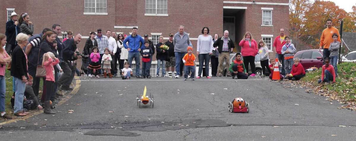 Spectators enjoy the competition between two pumpkin racers at the Newtown Lions’ Great Pumpkin Race. This year’s event will be Saturday, Oct. 17.