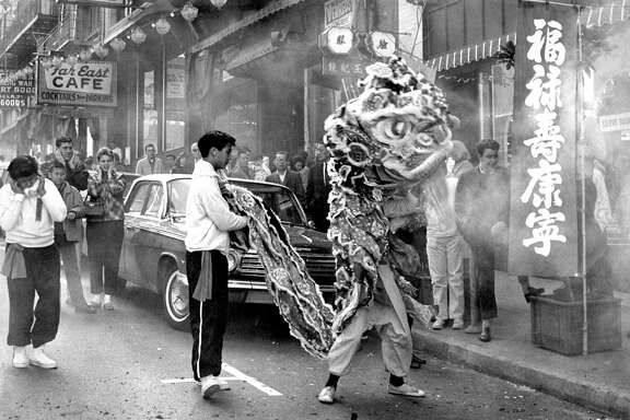 A lion dancer moves through the fireworks’ haze in San Francisco’s Chinatown on Feb. 16, 1964.