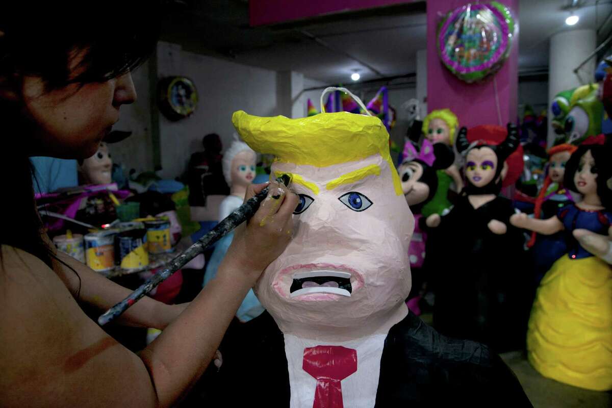 Alicia Lopez Fernandez paints a pinata depicting Donald Trump at her family's store "PiÃ©±atas Mena Banbolinos" in Mexico City. The piÃ©±ata was a special order made after Trump's comments that some Mexican immigrants to the U.S. bring drugs and crime, and some are rapists. (AP Photo/Marco Ugarte, File)