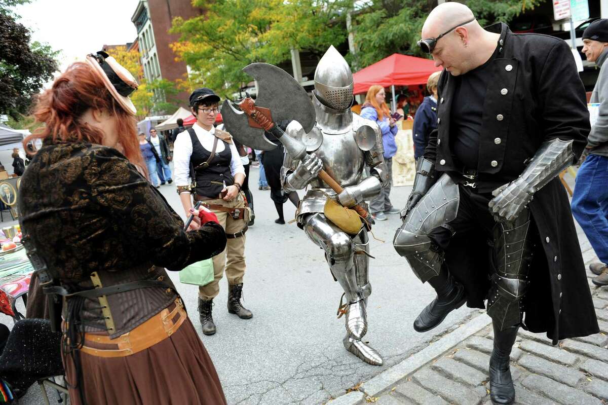 James Gillaspie of Albany, center, shows off his suit of armor as he mixes with others dressed up for the Enchanted City steampunk street festival on Saturday, Oct. 3, 2015, in Troy, N.Y. The family-friendly event offered music, games, performance, food and fantasy. (Cindy Schultz / Times Union)
