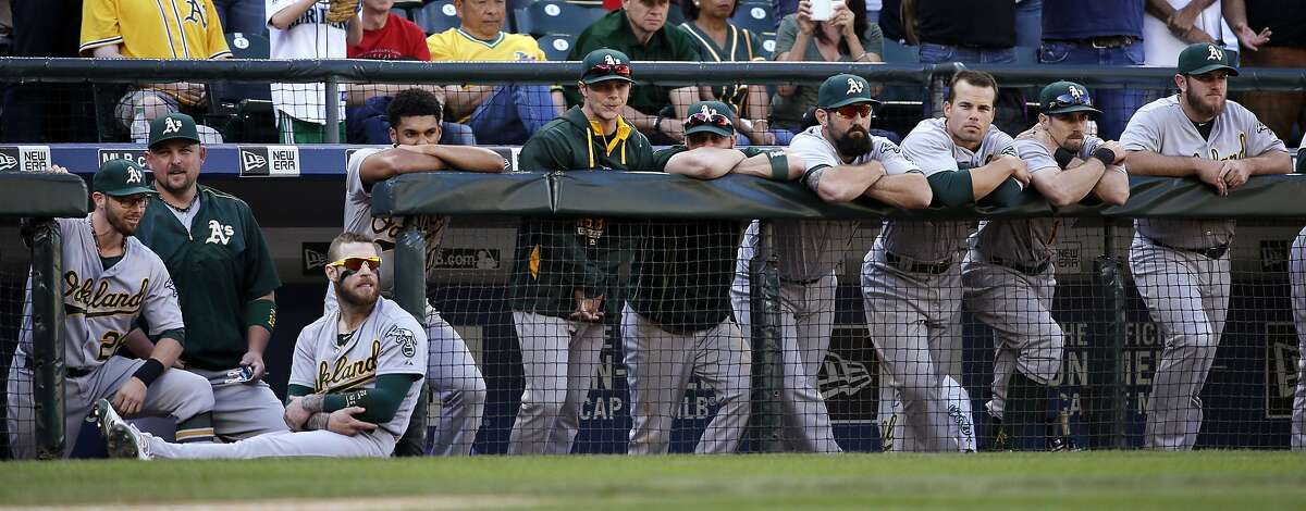 Oakland Athletics players watch the final out in the ninth inning of a baseball game against the Seattle Mariners Sunday, Oct. 4, 2015, in Seattle. The Mariners won 3-2. (AP Photo/Elaine Thompson)
