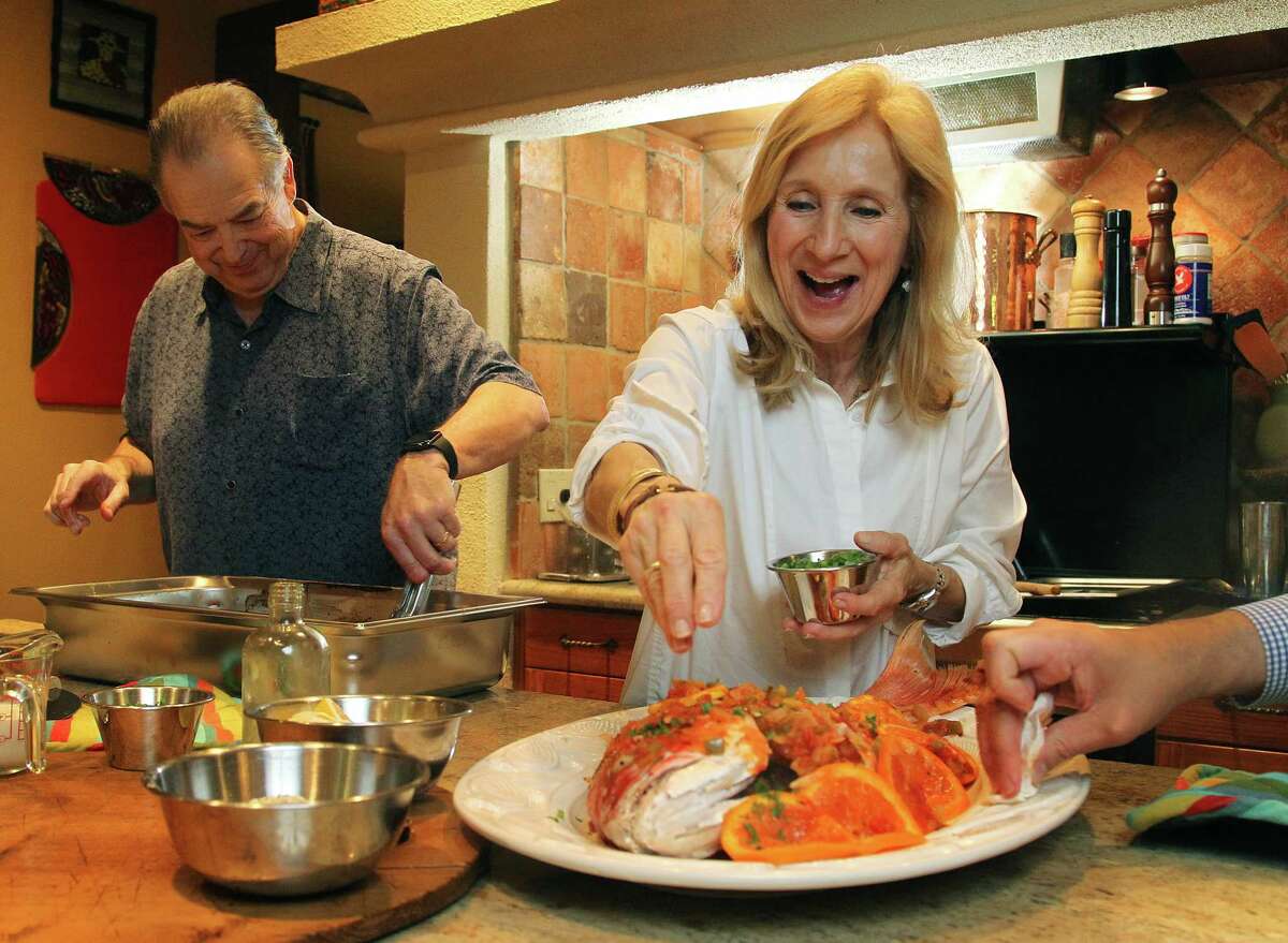 Jim and Diane Gossen put the finishing touches on a whole snapper in their home kitchen.