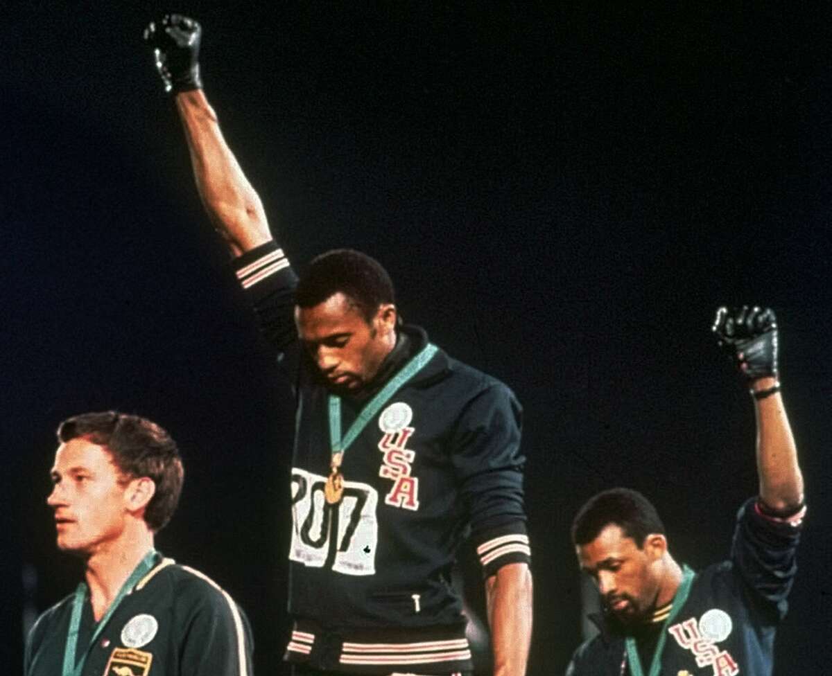 U.S. Olympians Tommie Smith, center, and John Carlos, right, give the black pride salute during the playing of the “Star Spangled Banner” after Smith received the gold medal and Carlos the bronze medal for the 200-meter run at the Summer Olympic Games in Mexico City in this Oct. 16, 1968, file photo.