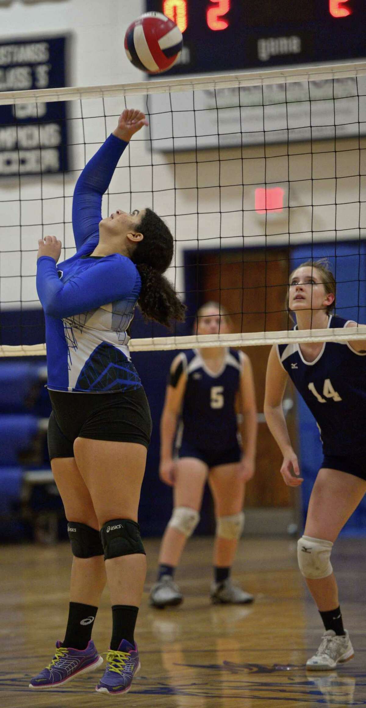 FILE PHOTO: Abbott Tech's Rhayssa Louzada (20) taps the ball over the net while Immaculate's Abby Unz moves in during the girls high school volleyball match between Henry Abbott Technical and Immaculate high school on Wednesday afternoon, September 23, 2015, at Immaculate High School, in Danbury, Conn.