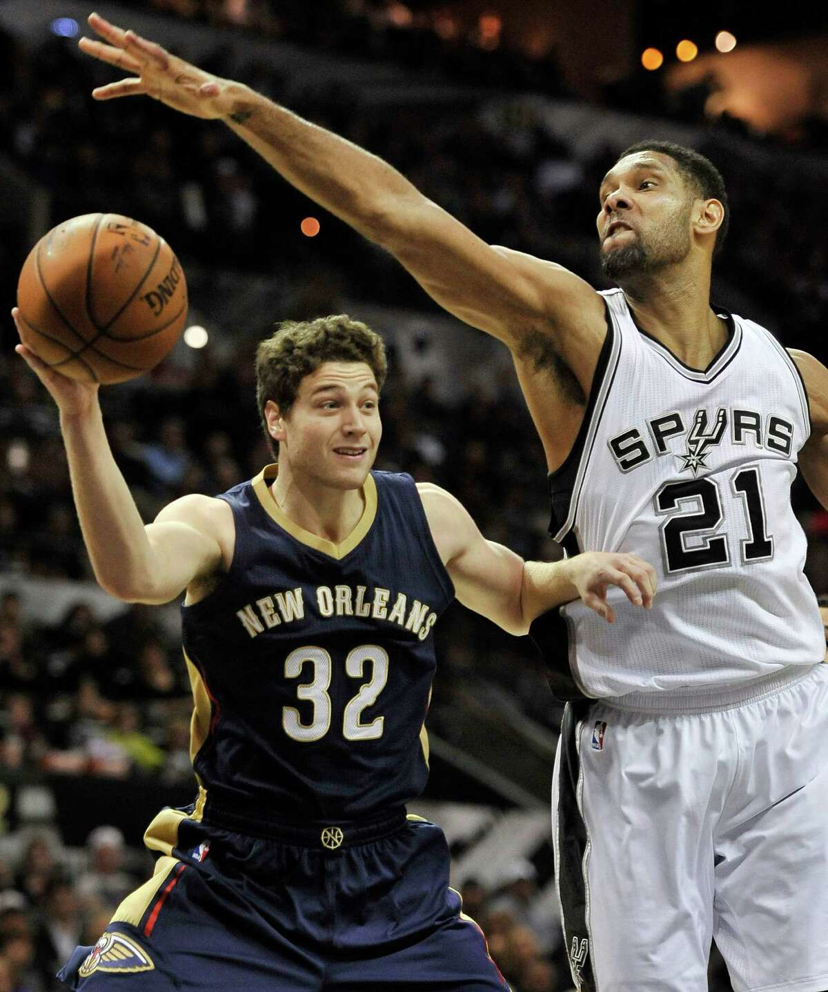 New Orleans Pelicans guard Jimmer Fredette (32) looks to pass around San Antonio Spurs forward Tim Duncan in the second half of an NBA basketball game, Wednesday, Dec. 31, 2014, in San Antonio. San Antonio won 95-93 in overtime. (AP Photo/Darren Abate)