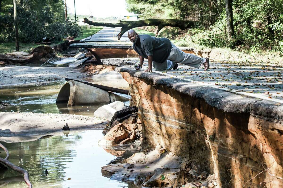 Trey McMillian looks at the damage caused by flooding on a road in Eastover, S.C. Water mains are broken, roads and bridges are out, and the potable water supply remains seriously compromised in South Carolina’s capital, Columbia.