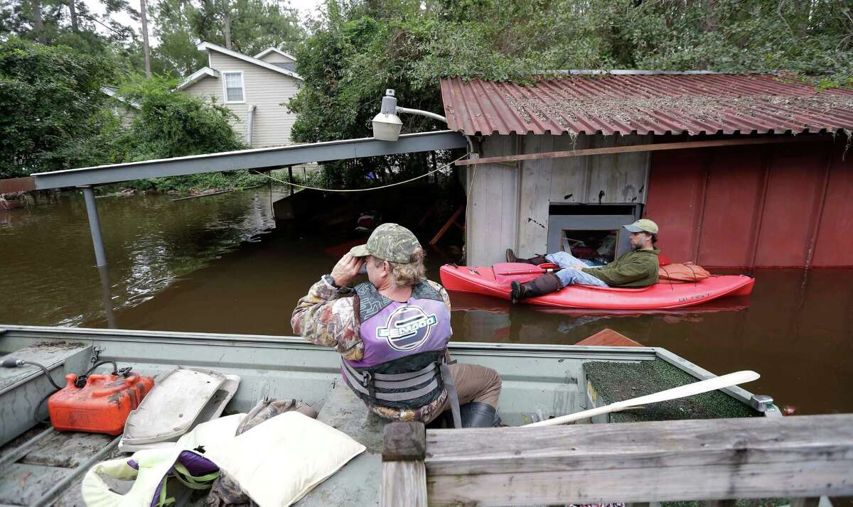 Robin Powers, of Florence, S.C. and Kip Jones, right, survey the flooding on Roundtree Road along the Lynches River in Effingham, S.C., Tuesday, Oct. 6, 2015. (AP Photo/Gerry Broome)