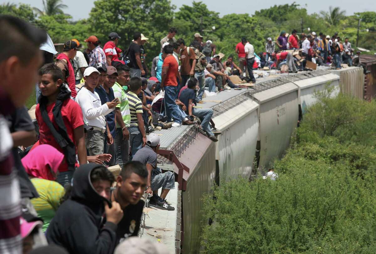 Immigrants arrive on top of a freight train at Ixtepec, Mexico. Thousands of Central American migrants ride the trains, known as “la bestia,” or the beast, during the journey through Mexico.