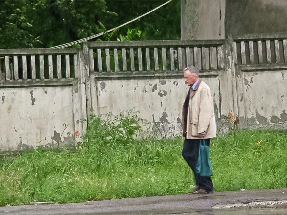 In this June 27, 2011 photo provided by the Moldova General Police Inspectorate, Teodor Chetrus carries a green sack containing a sample of uranium-235 in Chisinau, Moldova. Chetrus was a bit of paradox to investigators. He was educated and well dressed, yet still lived in his dilapidated childhood farmhouse in a tiny village on Moldova's border with Ukraine. (Moldova Police via AP)