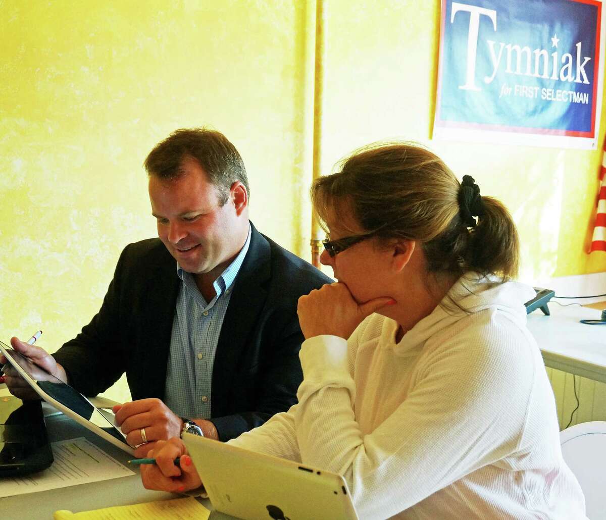 Republican first selectman candidate Chris Tymniak goes over some plans with running mate Laurie McArdle at their Unquowa Road headquarters.