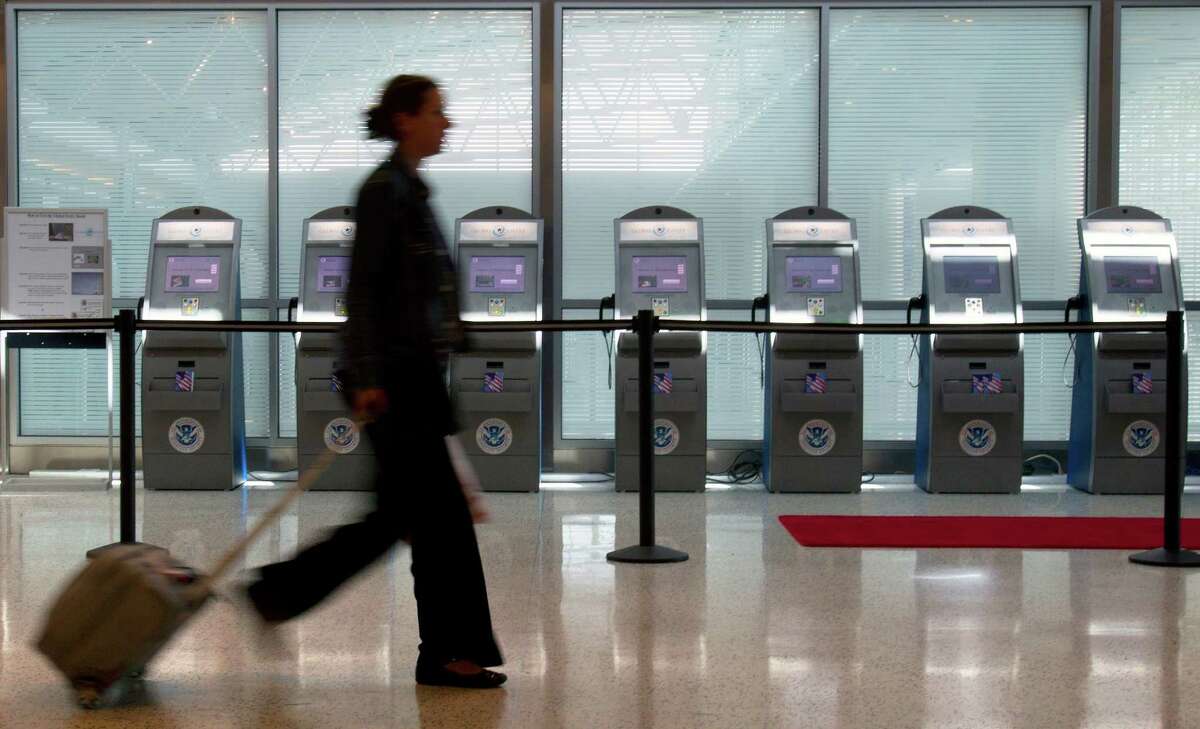 A passenger walks by Global Entry kiosks at George Bush Intercontinental Airport Wednesday, Aug. 10, 2011, in Houston. ( Cody Duty / Houston Chronicle )