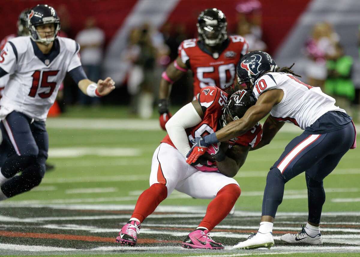 Falcons defensive tackle Jonathan Babineaux snags a pass intended for DeAndre Hopkins, right, for one of the Texans’ four turnovers Sunday.