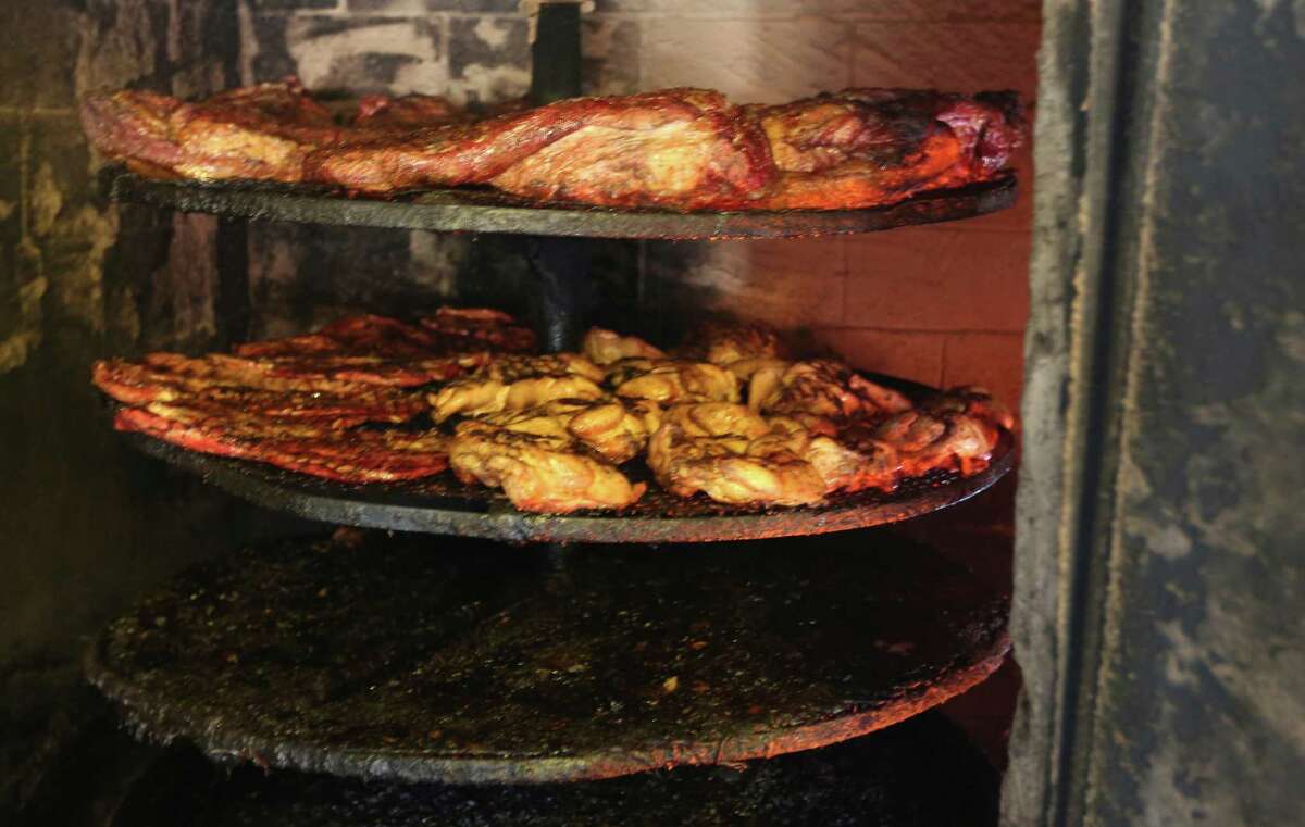 Meat from Seguin's Davila's BBQ is seen as it cooks inside one of the restaurant's several on-site smokers.