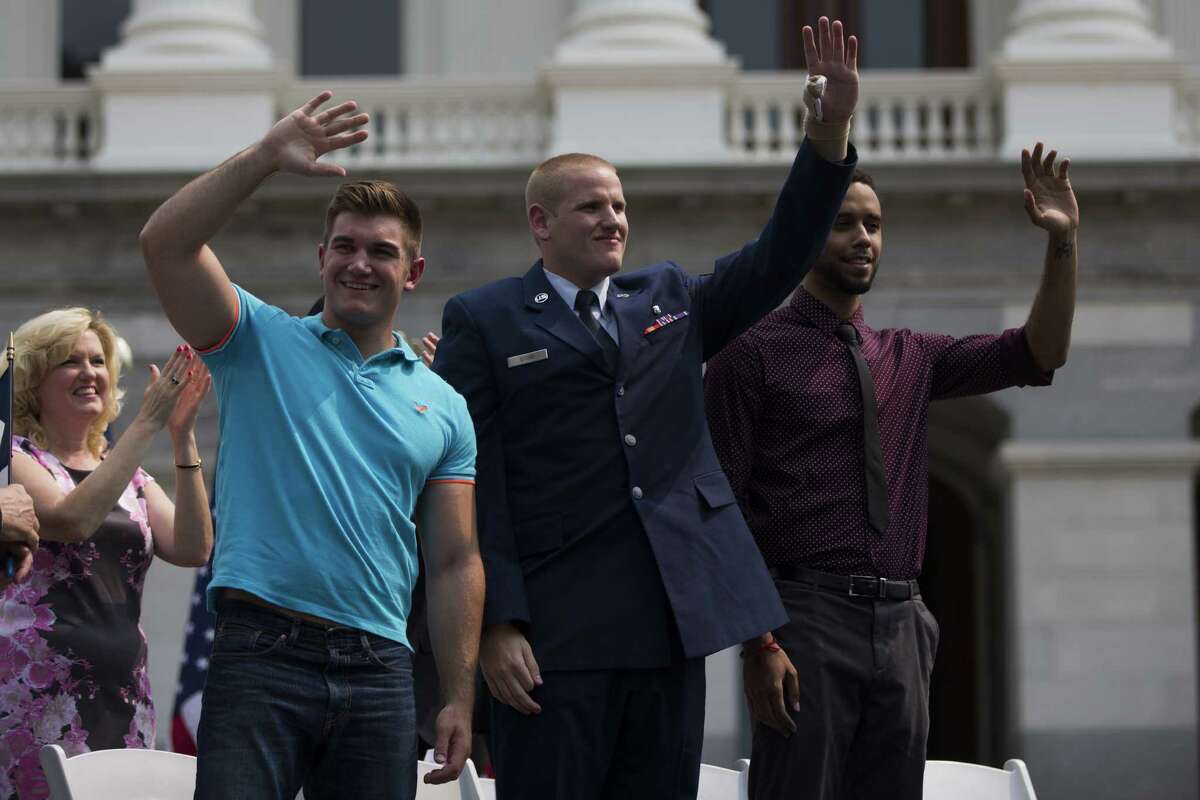 US Airman Spencer Stone, who helped to stop a terror attack on a train in France in August, has been stabbed several times, according to reports. (L-R) Alek Skarlatos, Spencer Stone and Anthony Sadler wave to the crowd during a parade honoring their August 21 actions in overpowering a gunman on a Paris-bound train on September 11, 2015 in Sacramento, California. Thousands lined the street along Capitol Mall to celebrate their hometown heroes. (Photo by Stephen Lam/ Getty Images)