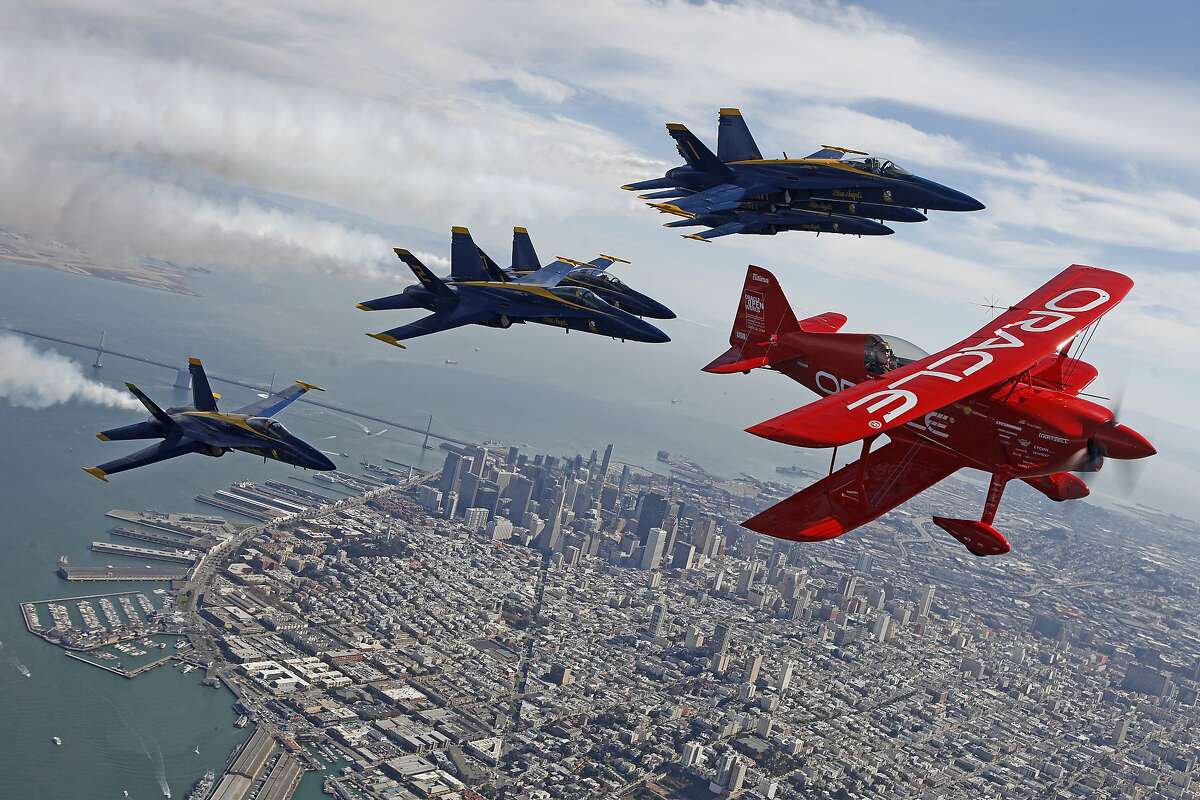 Led by Sean Tucker, an air show pilot, in a Challenger 3 stunt plane sponsored by Oracle, the Blue Angels do a practice flight on Thursday afternoon, October 8, 2015 in preparation for Fleet Week 2015 at the Oakland International Airport.