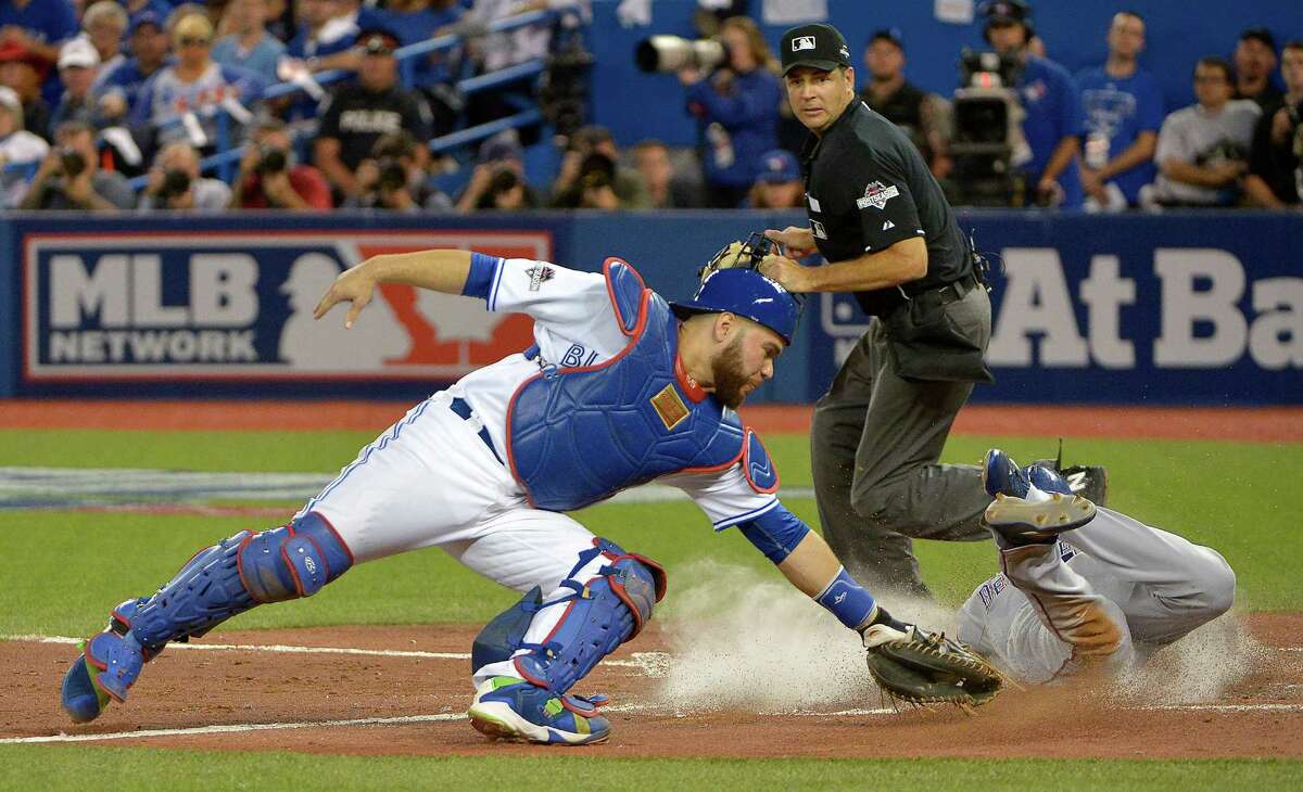 The Texas Rangers' Delino DeShields, right, scores on a single by teammate Adrian Beltre in the third inning as Toronto Blue Jays catcher Russell Martin, left, can't make the tag during Game 1 of the ALDS at Rogers Centre in Toronto on Thursday, Oct. 8, 2015. The Rangers won, 5-3. (Max Faulkner/Fort Worth Star-Telegram/TNS)