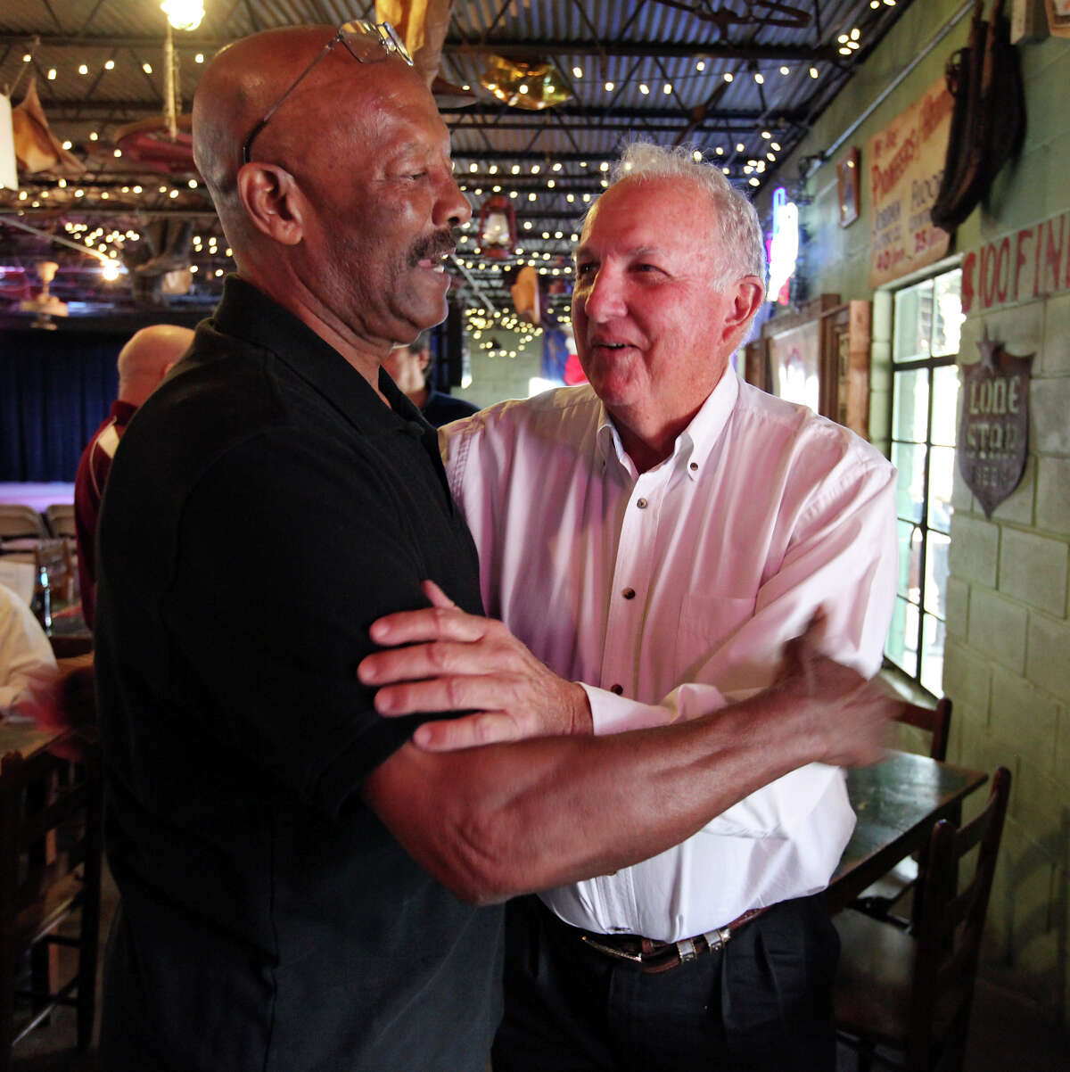 Former San Antonio Toros players Isadore Hannah (left) and Sonny Detmer joke during a reunion on April 12, 2014, at John T. Floore County Store in Helotes.