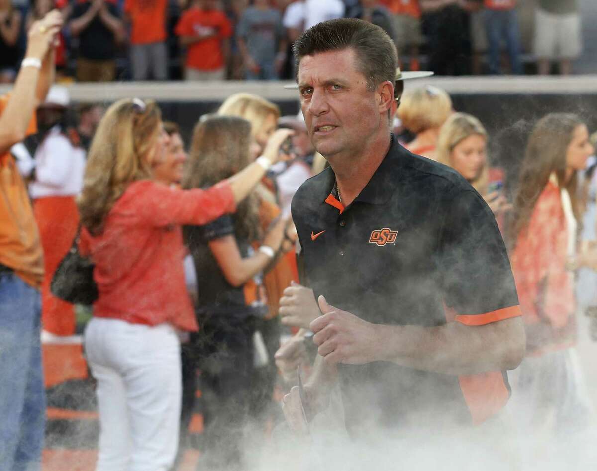 Oklahoma State head coach Mike Gundy runs onto the field before the game against Central Arkansas on Sept. 12, 2015.
