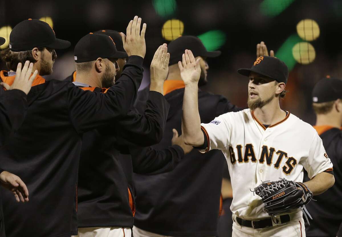 San Francisco Giants pitcher Mike Leake, right, celebrates the 5-0 defeat of the Los Angeles Dodgers with teammates at the end of a baseball game Wednesday, Sept. 30, 2015, in San Francisco. Leake pitched a complete game 2 hit shutout of the Dodgers. (AP Photo/Ben Margot)