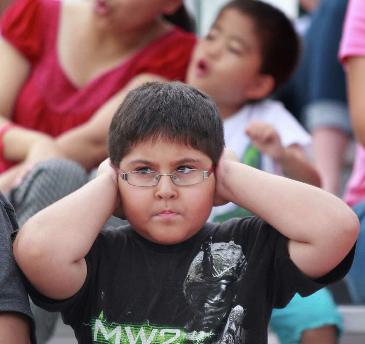 Fabian Arellano of Houston covers his ears while watching the IndyCar Series Race #1 at the Grand Prix of Houston at NRG Park in 2014.