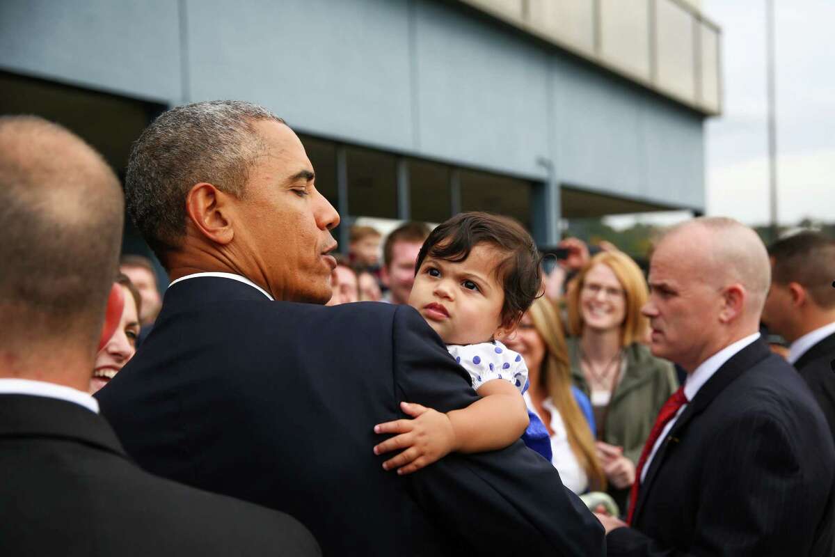 President Barack Obama holds six month-old Stella Hakam at Boeing Field during a brief visit to Seattle on Friday, Oct. 9, 2015. The president stopped in the Seattle area for a fundraiser and event to support Sen. Patty Murray, D-Wash. Obama came to Seattle after a stop in Roseburg, Oregon, where he visited a week after a school shooting there.