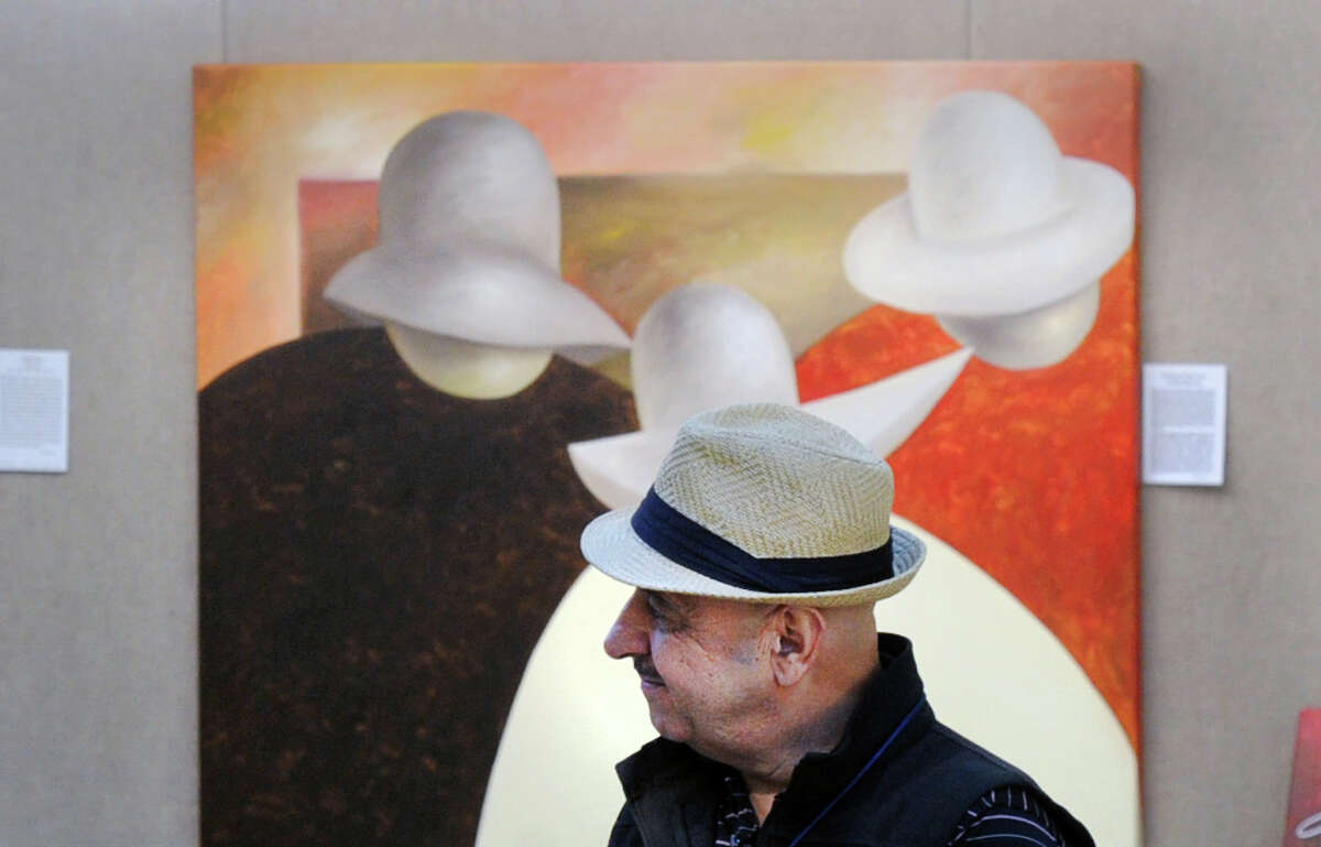 The New Mexican artist who goes by the name Guilloume stands in front of one of his paintings at the 34th annual Outdoor Arts Festival at the Bruce Museum in Greenwich on Saturday. The event features works by 85 artists from all over the country, along with live music, food trucks and family art activities. The festival continues Sunday, from 10 a.m. to 5 p.m., at the museum at 1 Museum Drive. Admission is $8.