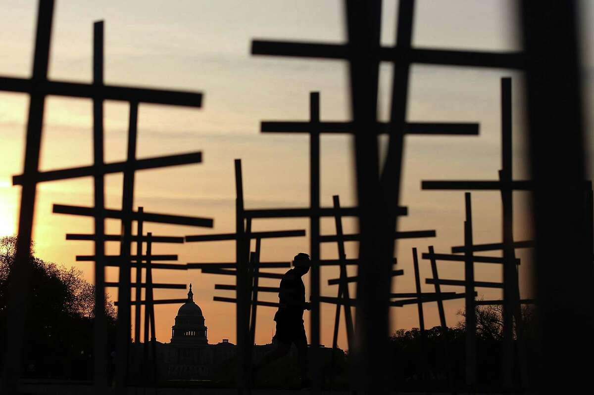 WASHINGTON, DC - APRIL 11: Volunteers place grave markers on the National Mall as over 3,300 crosses, stars of David, and other religious symbols are placed to remember those affected by gun violence, on April 11, 2013 in Washington, DC. Clergy from Newtown, Connecticut, and others will begin a 24- hour vigil to urge Congress into passing tougher gun laws. (Photo by Mark Wilson/Getty Images) *** BESTPIX ***