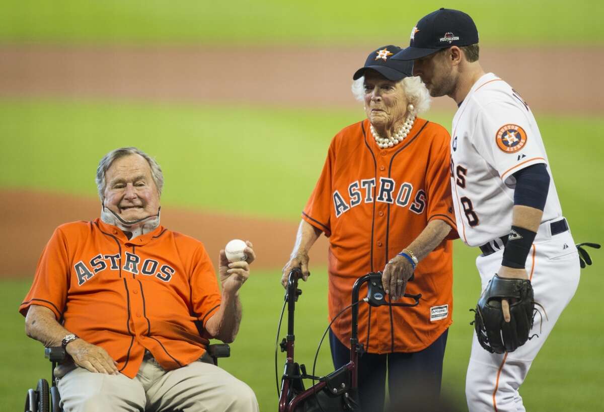 Former President George H.W. Bush, with former First Lady Barbara Bush, holds a baseball after throwing out the ceremonial first pitch to Astros third baseman Jed Lowrie (8)before Game 3 of the American League Division Series against the Kansas City Royals at Minute Maid Park Sunday, Oct. 11, 2015, in Houston. ( Brett Coomer / Houston Chronicle )