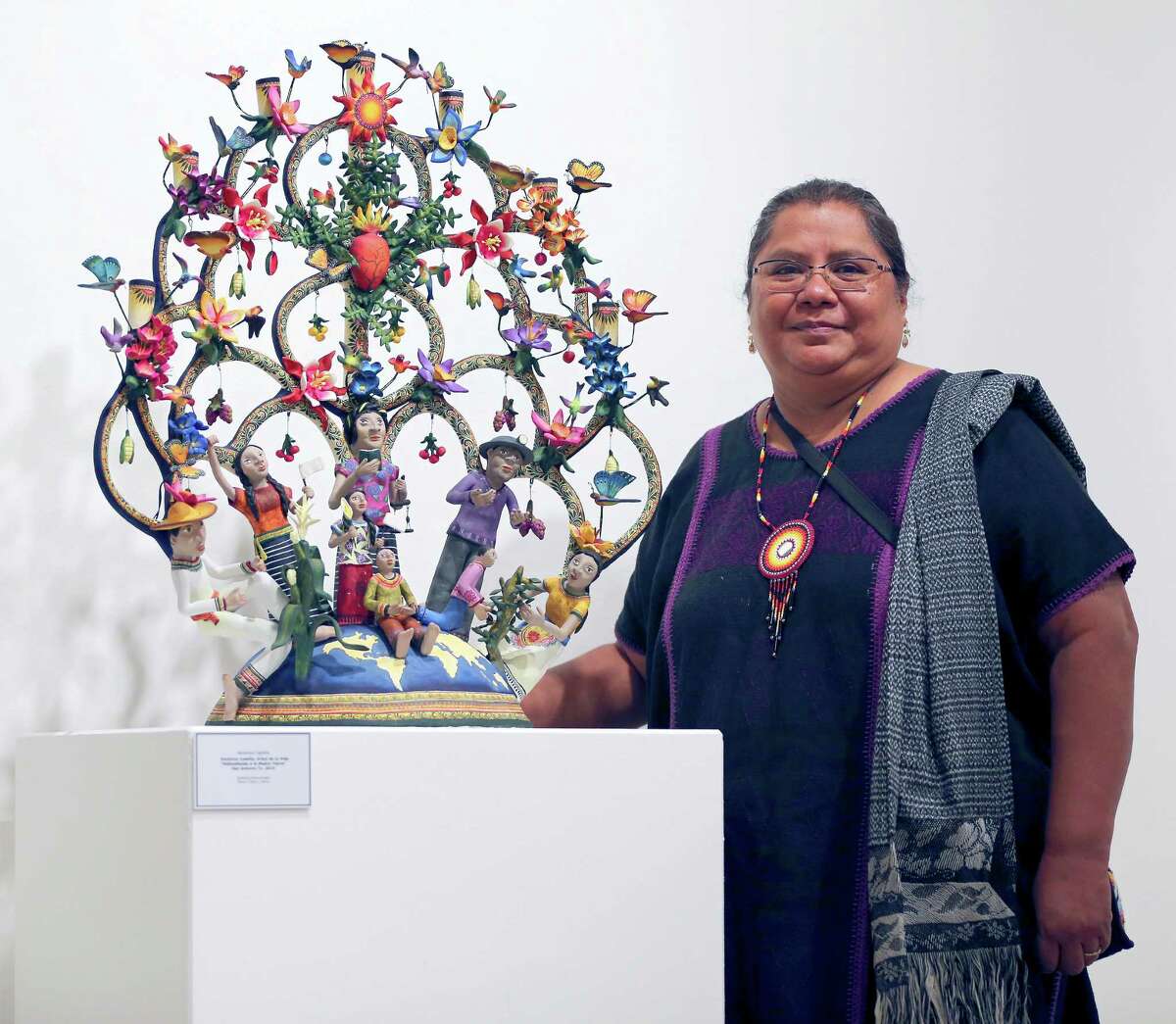 Veronica Castillo, a folk artist who was awarded an NEA National Heritage Fellowship in 2013 poses Oct. 6, 2015 next to one of her sculptures on display at the TAMU-SA Centro de Artes.