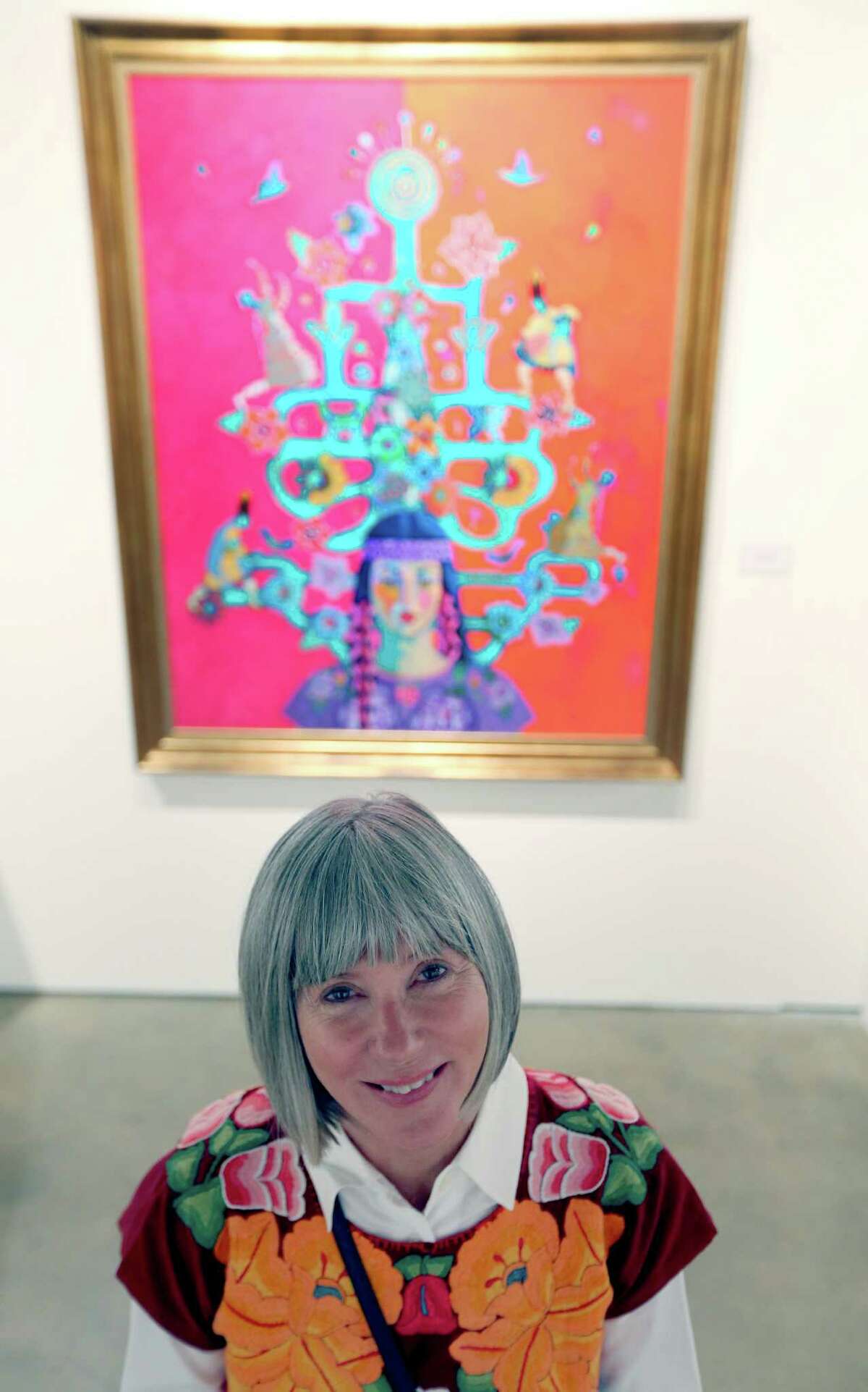 Kathy Sosa poses Oct. 6, 2015 in front of one of her paintings on display at the TAMU-SA Centro de Artes.