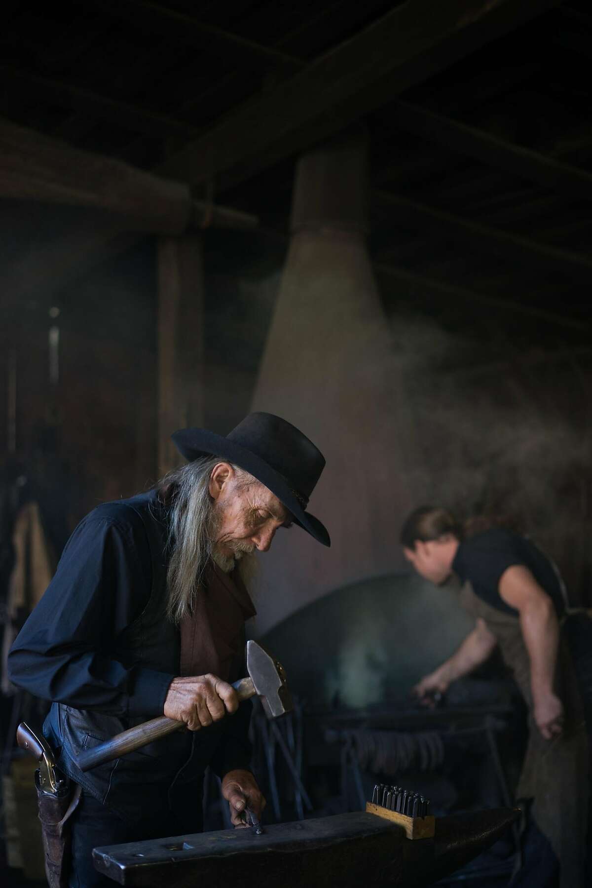 Mike Maciejewski hammers a small sword at the blacksmith shop at Columbia State Park in Columbia, Calif. on Friday, Oct. 9, 2015. Columbia has the largest number of gold rush-era buildings.