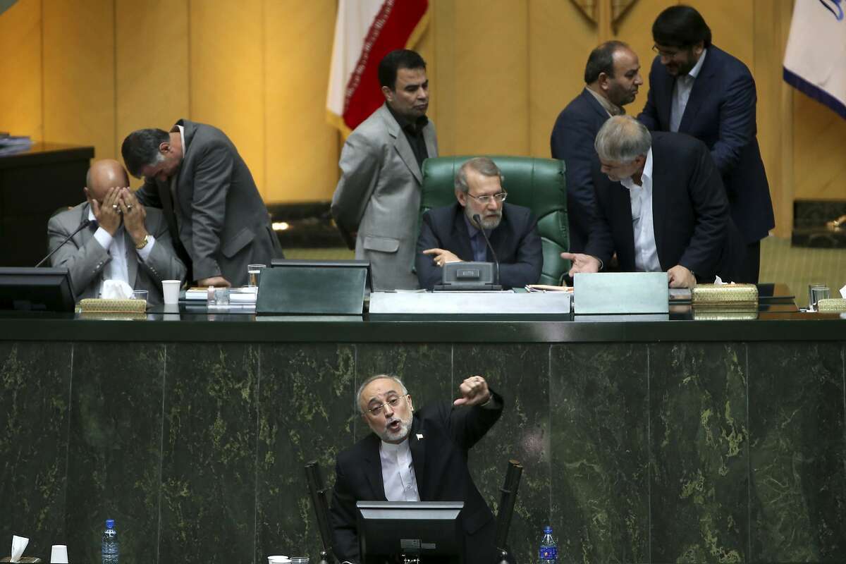 Head of Iran's Atomic Energy Organization Ali Akbar Salehi, bottom, speaks in an open session of parliament while discussing a bill on Iran's nuclear deal with world powers, in Tehran, Iran, Sunday, Oct. 11, 2015. Iran's official IRNA news agency reported Sunday the country's parliament has approved an outline of a bill that allows the government to implement a historic nuclear deal reached between Iran and world powers. (AP Photo/Ebrahim Noroozi)