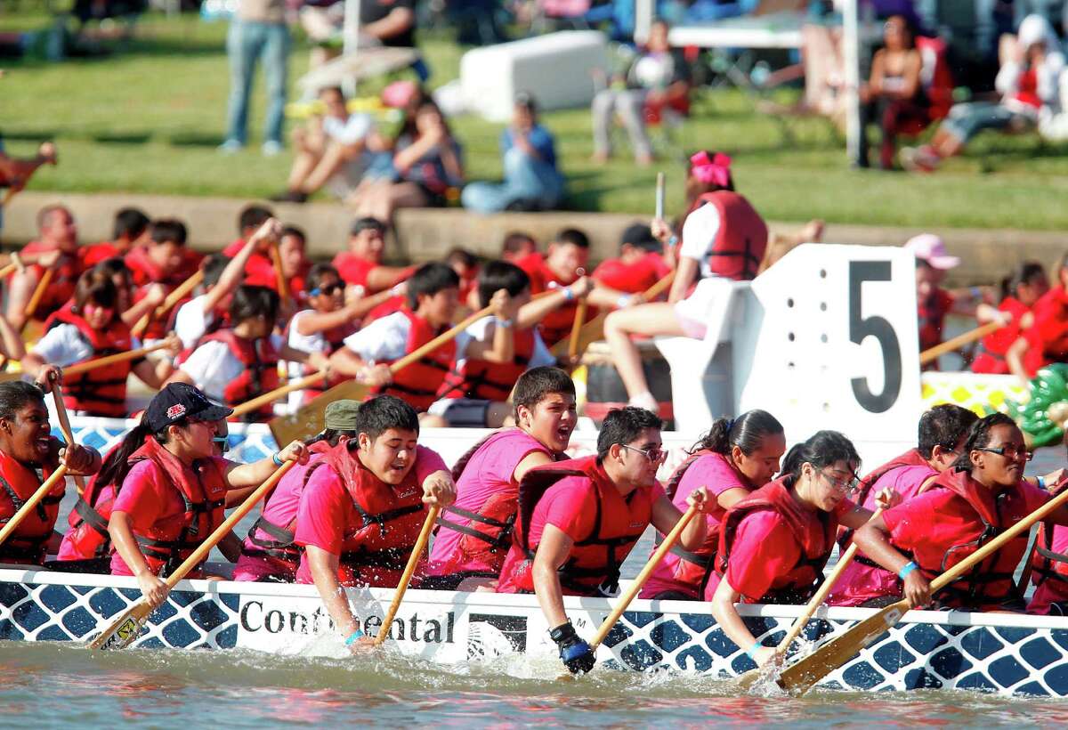(foreground) Sharpstown International School Team competes in the first round of races during The 8th Annual Gulf Coast International Dragon Boat Regatta held at Brooks Lake on Saturday, Oct. 20, 2012, in Sugar Land. The competition continues Sunday and concludes at 4 p.m. winners are recognized. ( Mayra Beltran / Houston Chronicle )