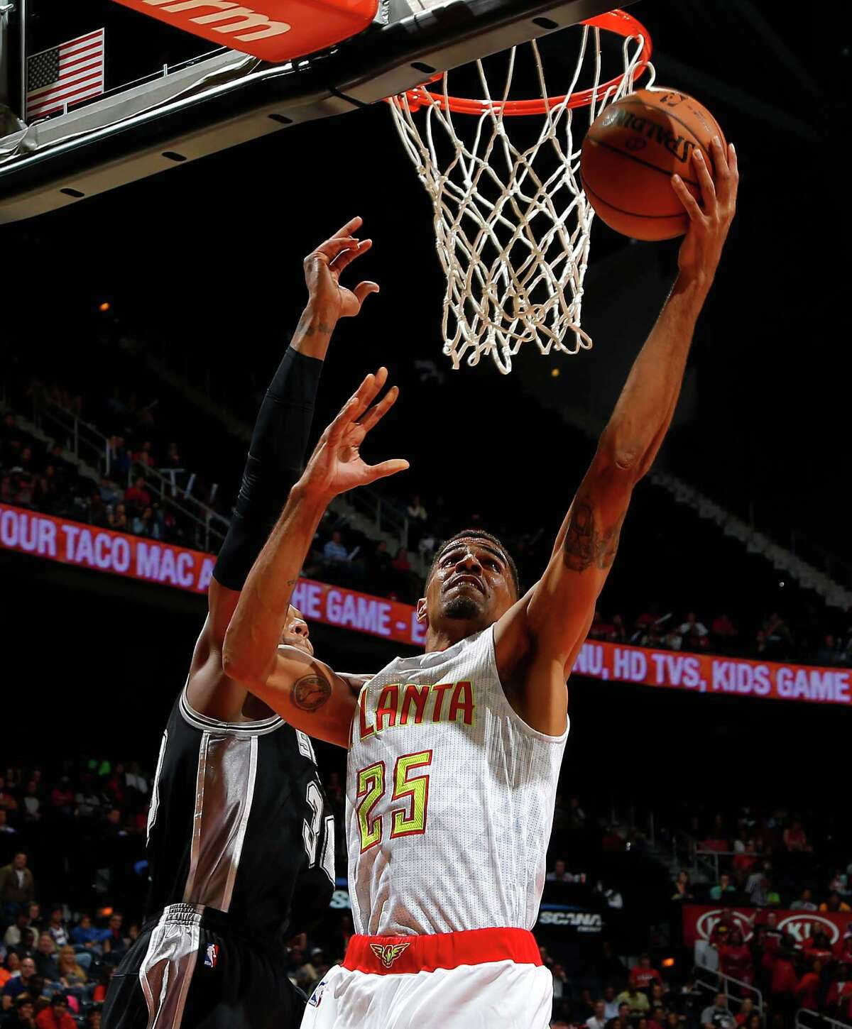 ATLANTA, GA - OCTOBER 14: Thabo Sefolosha #25 of the Atlanta Hawks lays in a basket against David West #30 of the San Antonio Spurs at Philips Arena on October 14, 2015 in Atlanta, Georgia. NOTE TO USER User expressly acknowledges and agrees that, by downloading andor using this photograph, user is consenting to the terms and conditions of the Getty Images License Agreement.
