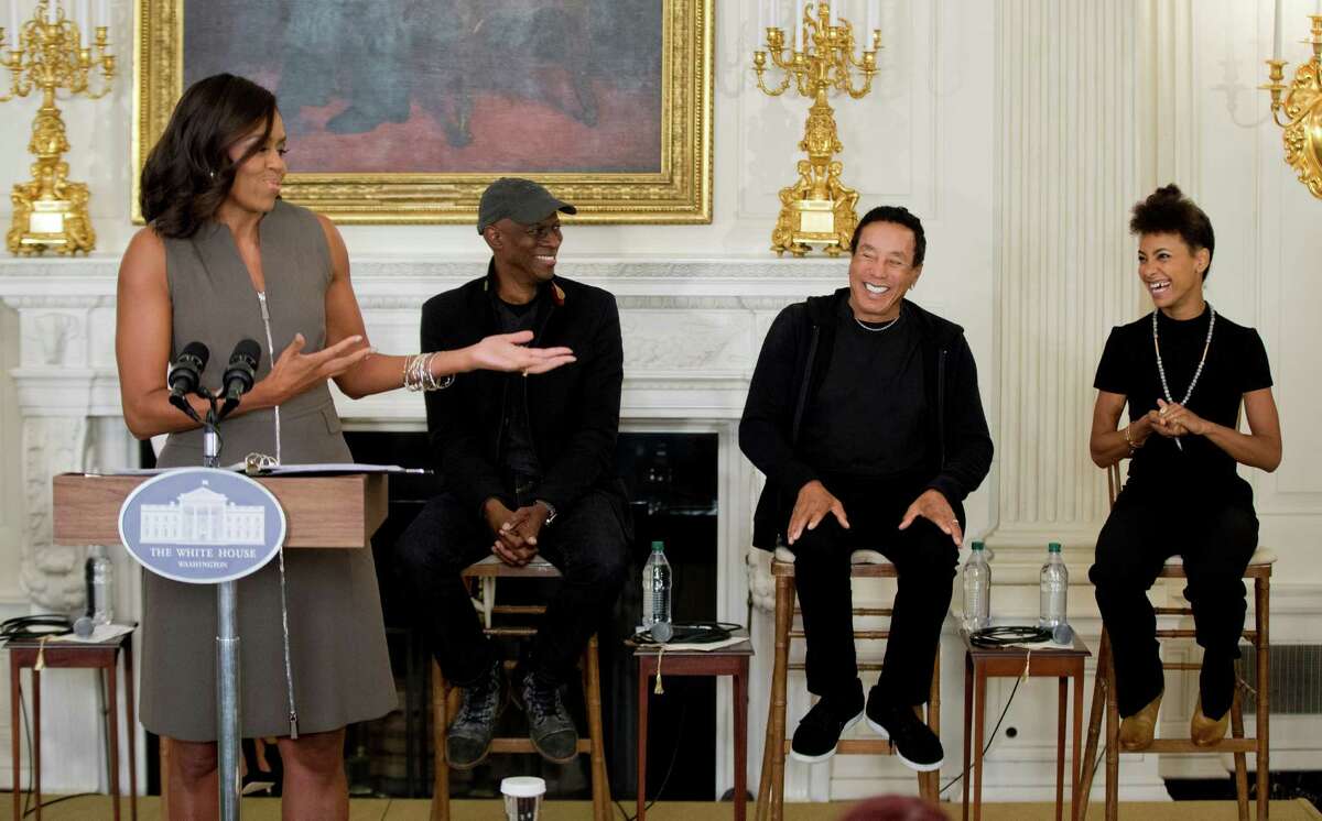 Grammy award-winning blues musician Keb?’ Mo?’; back, second from left to right, singer-songwriter Smokey Robinson and jazz musician Esperanza Spalding, laugh, reacting to comments by first lady Michelle Obama as she speaks to welcome middle school students from the Washington area for an interactive student workshop, Wednesday, Oct. 14, 2015, in the State Dining Room of the White House in Washington. A concert at the White House marks 50th anniversary of the National Endowment for the Arts and Humanities. (AP Photo/Manuel Balce Ceneta) ORG XMIT: DCMC103