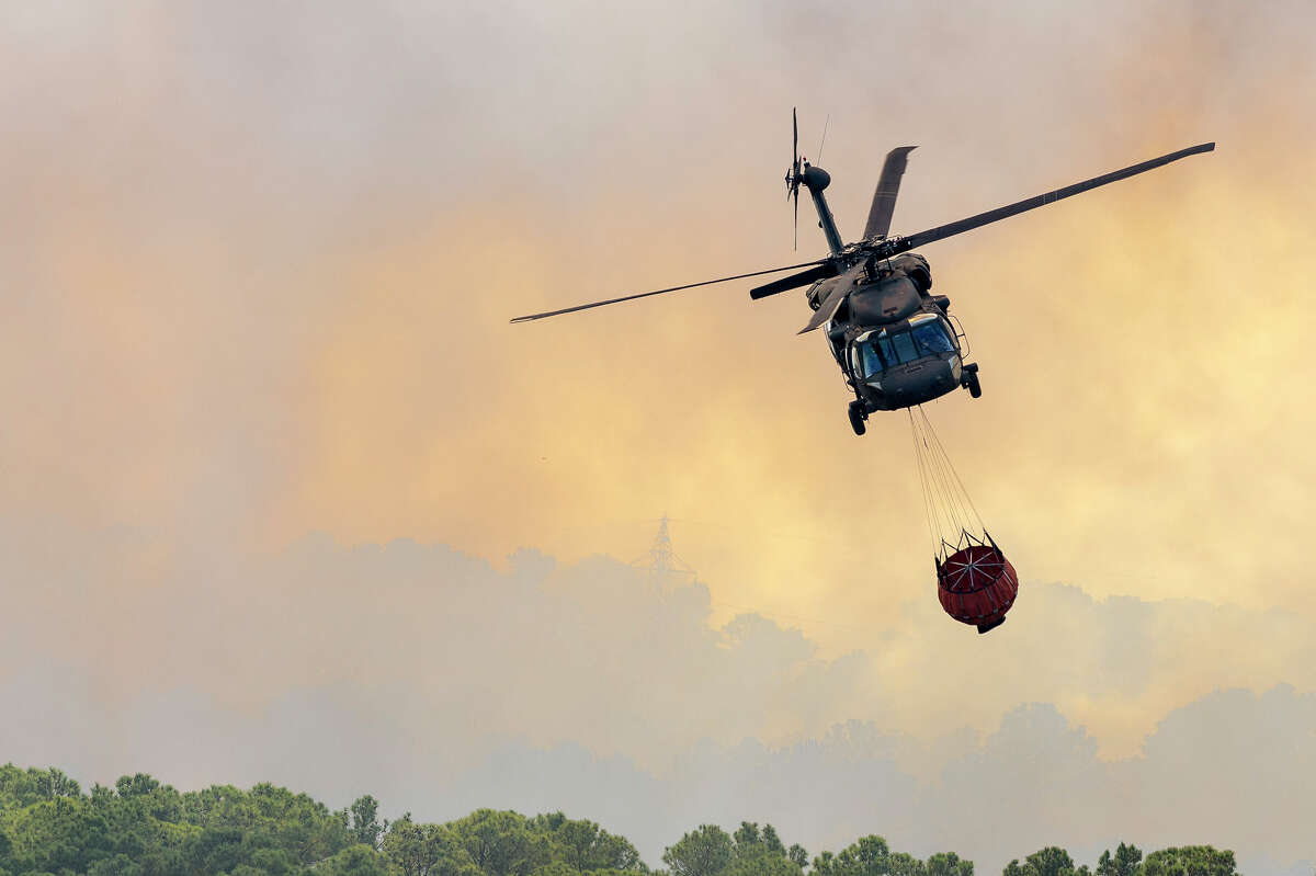 A Texas Army National Guard UH-60 Blackhawk out of the Austin Army Aviation Facility helps fight wild fires threatening homes and property near Bastrop, Texas, Oct. 14, 2015.