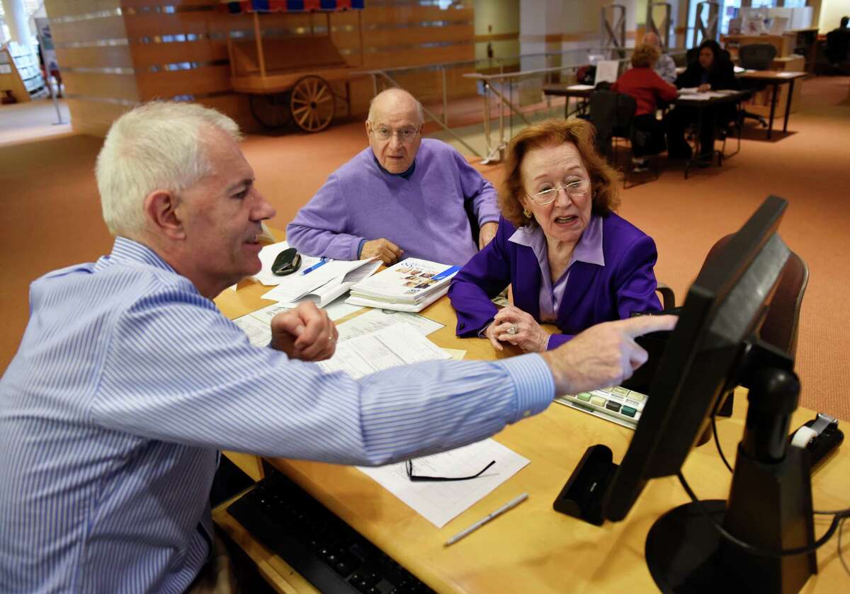Volunteer counselor Richard Porter, left, helps Greenwich residents Anthony and Marie Taverna select a new plan at the Commission on Aging's free Medicare counseling at the Greenwich Libraryin Greenwich, Conn. Thursday, Oct. 15, 2015. With annual enrollment just beginning, trained volunteers are offering advice on original Medicare, Medicare D, Medicare Supplement Insurance (Medigap) and other related health insurance options.