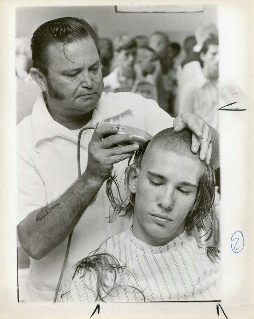 A barber shaves the head of an enlistee during basic training at Lackland Air Force Base in 1978.