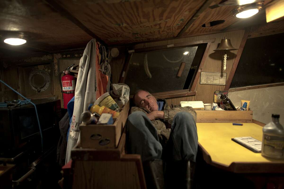 Ronnie Anderson, one of Erik Sandquist's longtime crew members, takes a nap in the early morning in the hull of the Mya Nicole as they set out to fish anchovies on October 7, 2015. (Photo by Tim Hussin)
