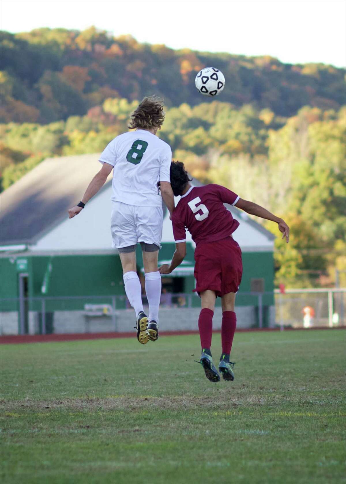 New Milford’s Cooper Knight (8) and Bethel’s Sergio Zapata (5) battle for position during their boys soccer game at New Milford High School on Thursday, October 15th, 2015.